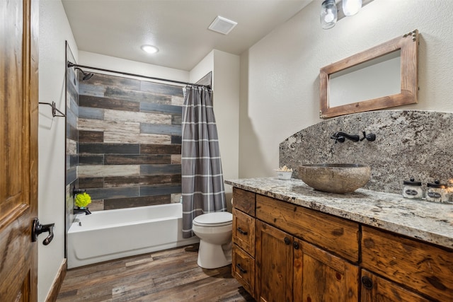 full bathroom with wood-type flooring, vanity, toilet, and shower / tub combo with curtain