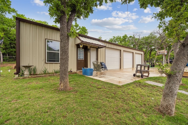 back of property with a garage and a yard