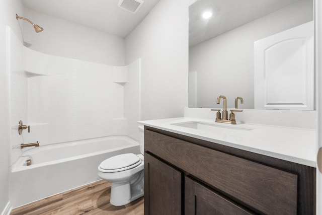 full bathroom featuring shower / bathing tub combination, hardwood / wood-style floors, vanity, and toilet