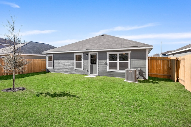 rear view of house with a yard and cooling unit