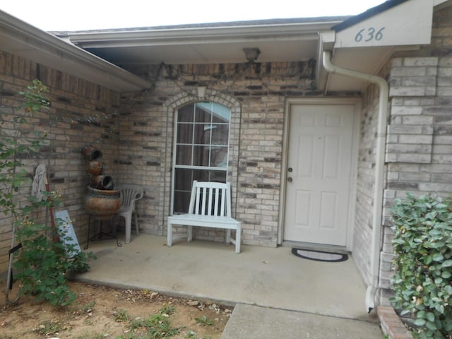 view of exterior entry with a patio area