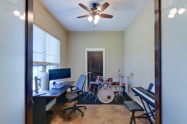 home office with ceiling fan and concrete floors