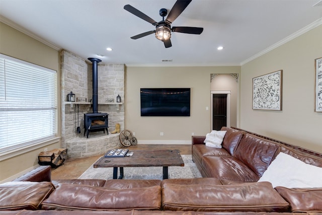 living room with a wood stove, ceiling fan, and ornamental molding