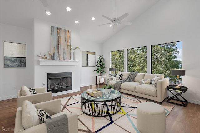 living room with ceiling fan, wood-type flooring, and high vaulted ceiling