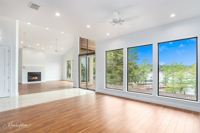 unfurnished living room with a towering ceiling and a healthy amount of sunlight