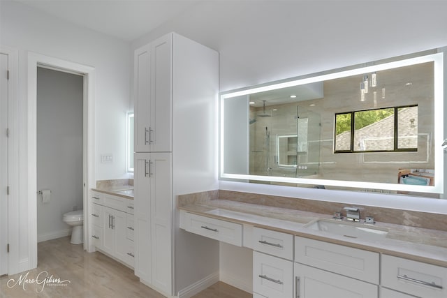 bathroom featuring vanity, hardwood / wood-style flooring, toilet, and an enclosed shower