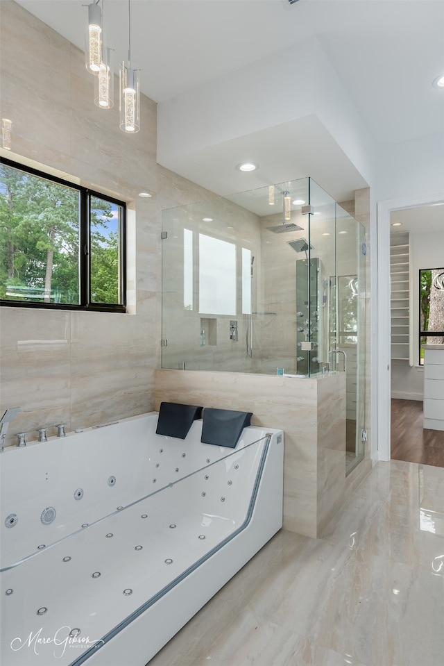 bathroom with a shower with door and tile walls