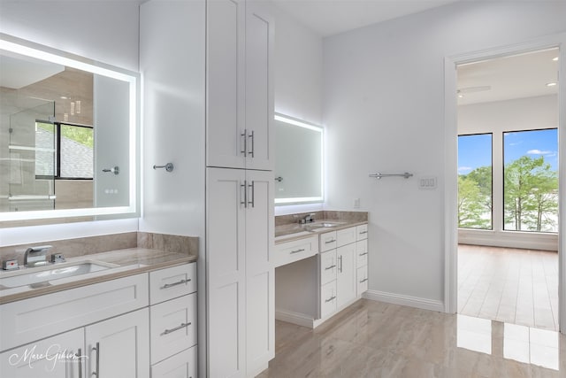 bathroom featuring tile patterned flooring, plenty of natural light, walk in shower, and vanity