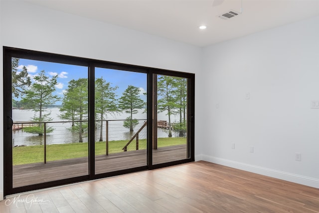 doorway with a water view and light wood-type flooring