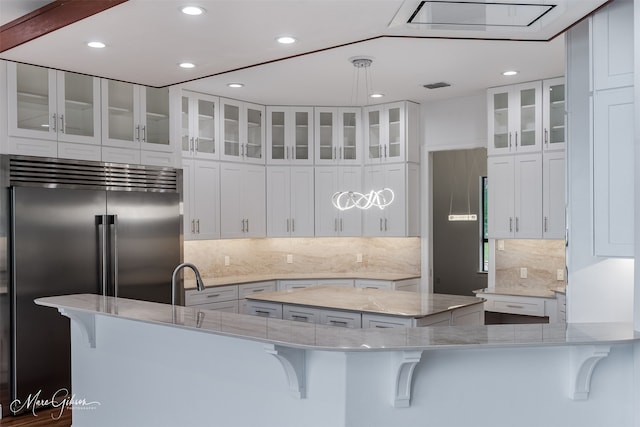 kitchen featuring white cabinets, stainless steel built in fridge, and a kitchen island