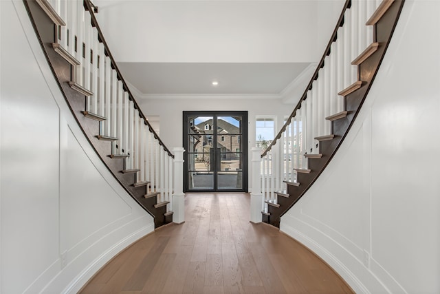 entrance foyer with hardwood / wood-style floors, french doors, and ornamental molding