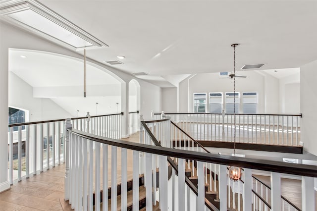 hallway with wood-type flooring and vaulted ceiling