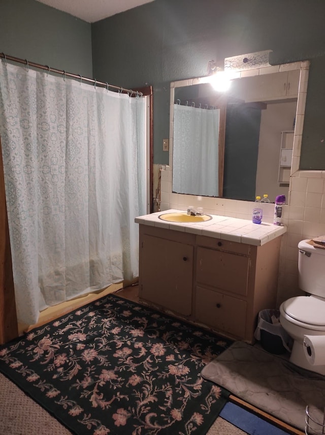 bathroom featuring vanity, curtained shower, toilet, and tile walls