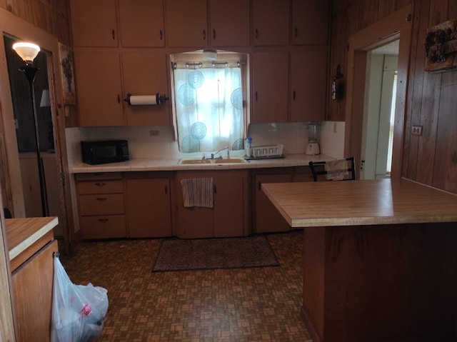 kitchen featuring decorative backsplash, sink, and wooden walls