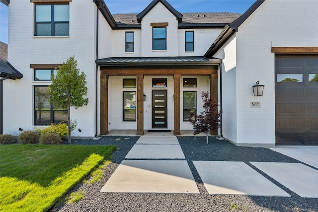 doorway to property featuring a lawn and a garage