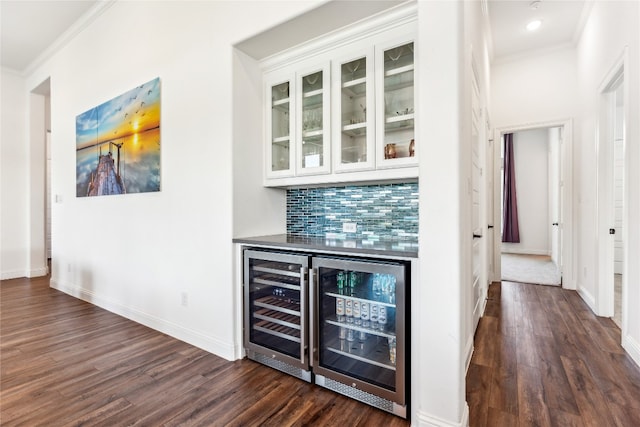 bar featuring beverage cooler, dark hardwood / wood-style flooring, tasteful backsplash, and crown molding