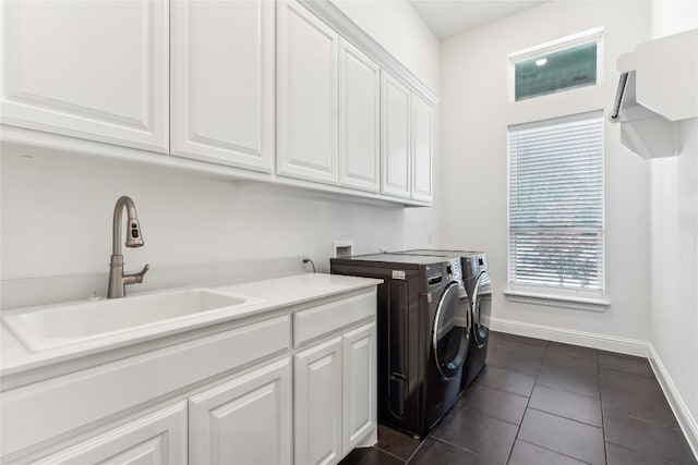 clothes washing area with dark tile floors, cabinets, washer and clothes dryer, sink, and washer hookup