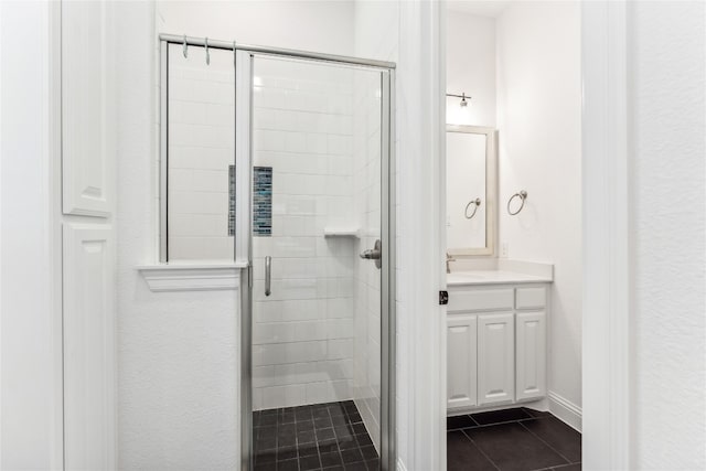 bathroom with a shower with shower door, tile flooring, and vanity