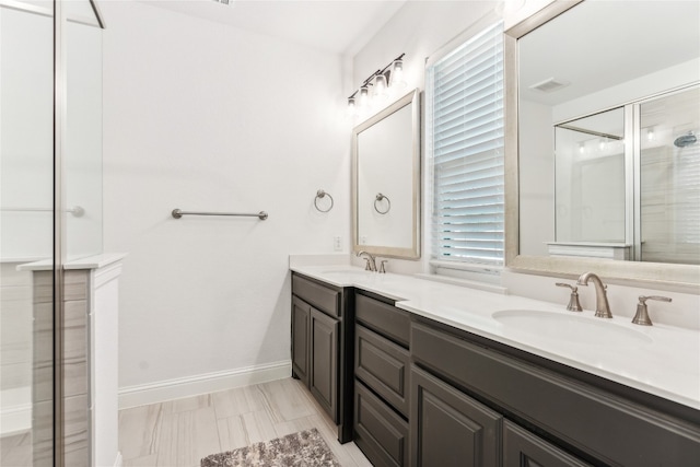 bathroom with dual sinks, large vanity, and tile floors