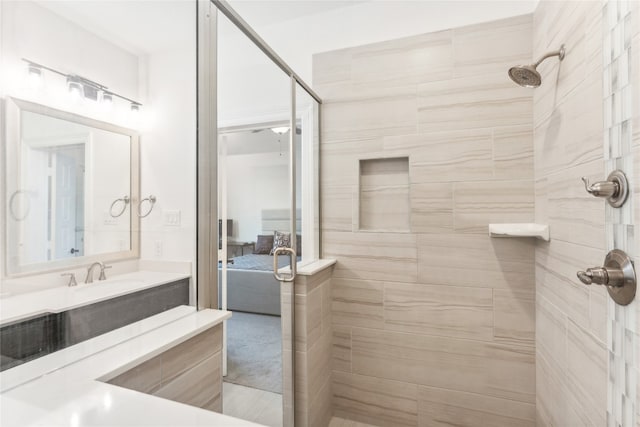 bathroom with vanity and a tile shower