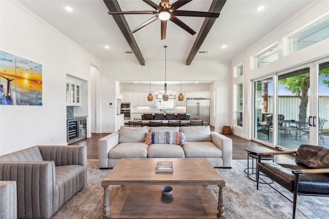 living room with crown molding, beverage cooler, ceiling fan with notable chandelier, hardwood / wood-style flooring, and beamed ceiling