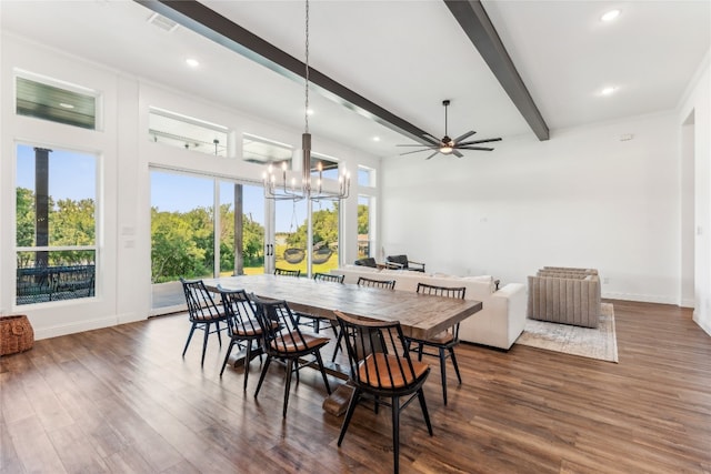 dining room with beamed ceiling, a healthy amount of sunlight, ceiling fan with notable chandelier, and dark hardwood / wood-style floors