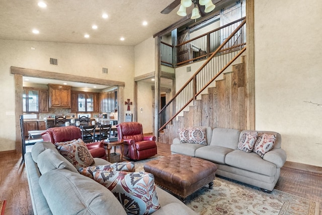 living room with high vaulted ceiling, ceiling fan, and light hardwood / wood-style flooring