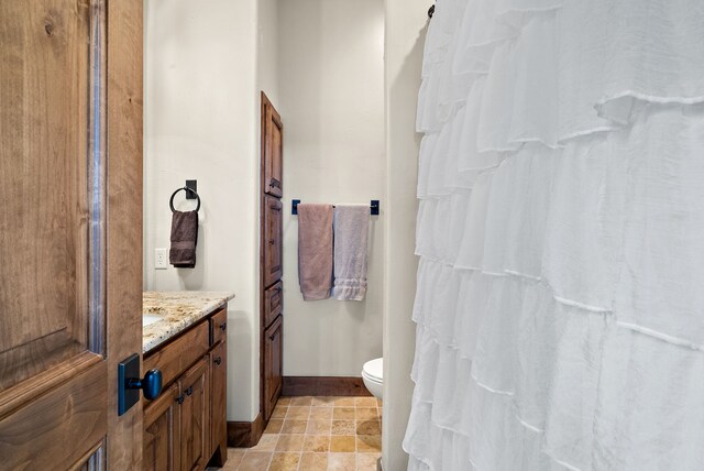 tiled bedroom featuring a closet, ceiling fan, and ensuite bathroom