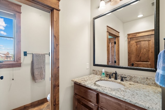 bathroom with large vanity and toilet