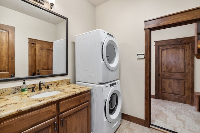 washroom featuring stacked washer and clothes dryer and sink