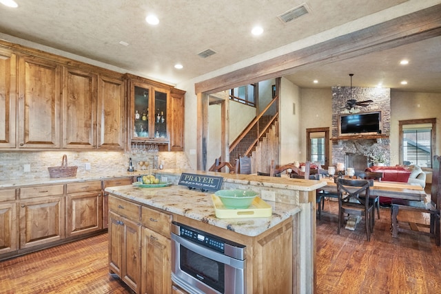 kitchen with dark hardwood / wood-style flooring, lofted ceiling with beams, a kitchen island, and backsplash