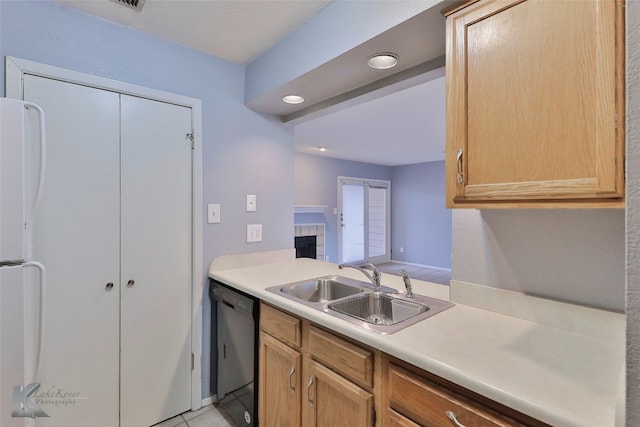 kitchen with light tile floors, sink, a tiled fireplace, white refrigerator, and black dishwasher