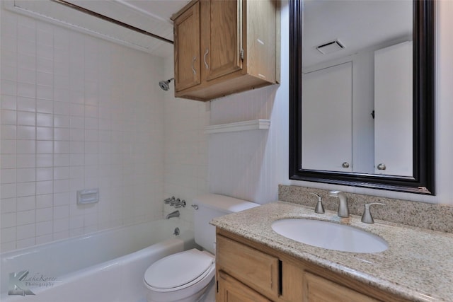 full bathroom featuring tiled shower / bath, vanity, and toilet