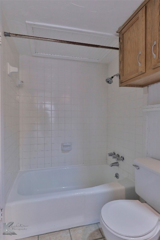 bathroom featuring tile floors, tiled shower / bath combo, and toilet