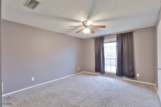 empty room with ceiling fan, carpet, and a textured ceiling