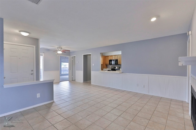 tiled spare room with ceiling fan