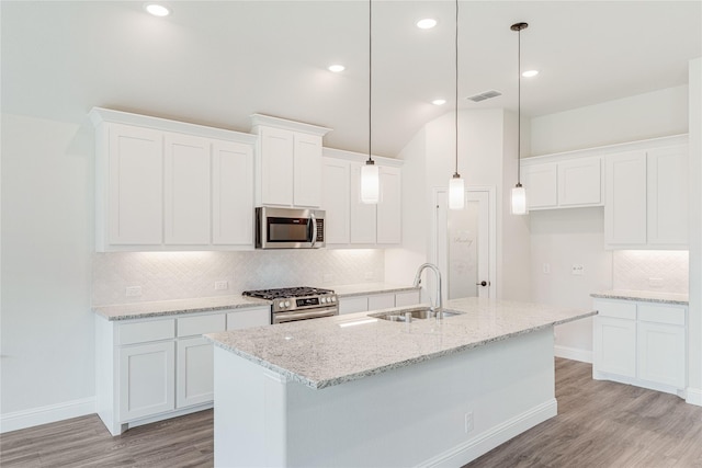 kitchen featuring white cabinetry, sink, decorative light fixtures, and stainless steel appliances