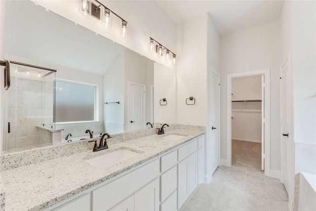 bathroom with a shower with door, vanity, and tile patterned floors