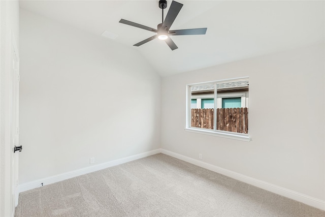 empty room with vaulted ceiling, ceiling fan, and carpet floors