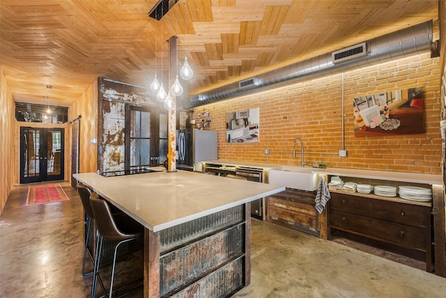 kitchen with a kitchen island, wood ceiling, brick wall, and sink