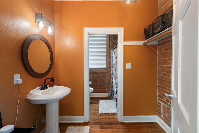 bathroom featuring wood-type flooring and toilet