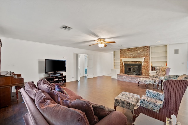 living room with ceiling fan, wood-type flooring, built in features, and a brick fireplace