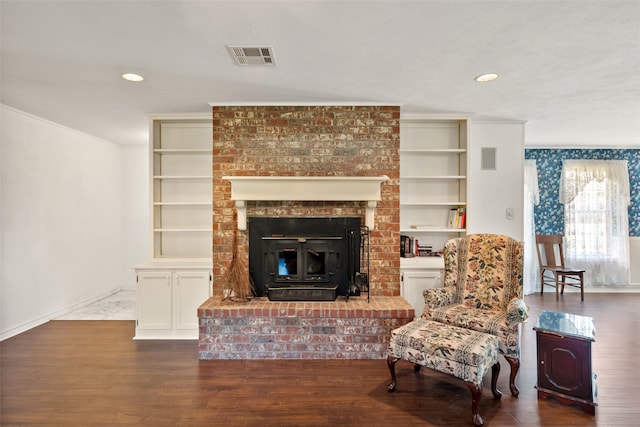 living area with dark hardwood / wood-style flooring, built in features, and crown molding