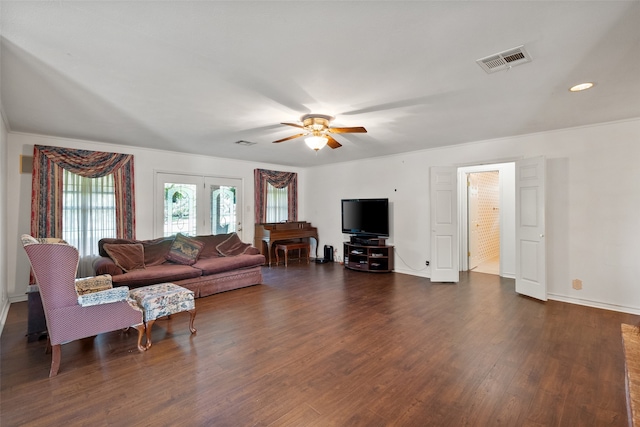 living room with dark wood-type flooring, ornamental molding, and ceiling fan