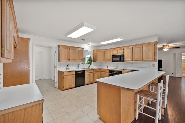 kitchen featuring sink, black appliances, kitchen peninsula, a kitchen breakfast bar, and ceiling fan