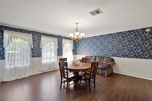 dining room featuring a chandelier, a healthy amount of sunlight, and dark hardwood / wood-style flooring