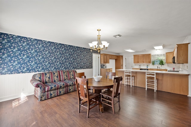 dining area featuring dark wood-type flooring and a notable chandelier