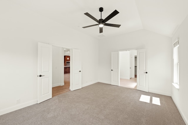 unfurnished bedroom featuring lofted ceiling, ceiling fan, and light colored carpet