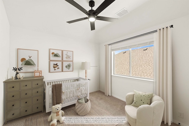 bedroom featuring carpet, ceiling fan, and a nursery area