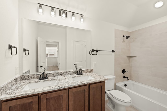 full bathroom featuring tiled shower / bath combo, vanity, and toilet